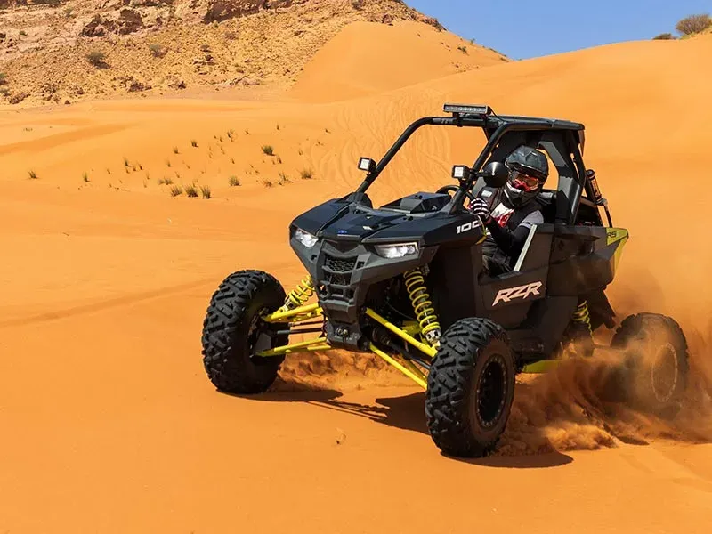 Dune buggy desert safari in Dubai with a driver in a helmet