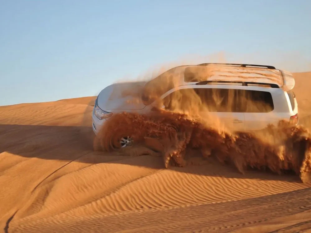 Private desert safari in Dubai with a Land Cruiser on red dunes